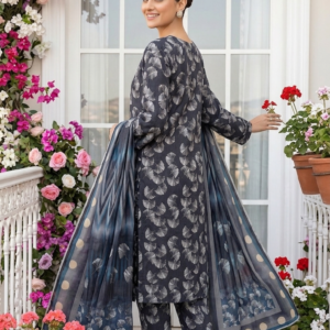 Back view of a model looking over her shoulder wearing the ginkgo maze 3 piece premium lawn suit, highlighting the continuous fan leaf print on the trousers and the fully flared chevron stripe and polka dot dupatta.