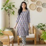 Model posing in a matching 2-piece soft off-white lawn co-ord set with Gulaabi phool aur neeli pattiyan (Magenta Flowers & Royal Blue Vines) floral block print motifs.