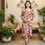 Model posing in a matching 2-piece earthy terracotta rust lawn twin set with white geometric daisy bunch prints.