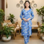 Model posing in a matching 2-piece bright cornflower blue lawn twin set with white and yellow ring motifs.