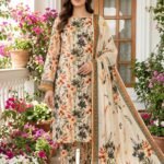 Model posing outdoors in a matching 3-piece warm ivory and terracotta orange botanical trail printed lawn suit with an olive green bordered dupatta.