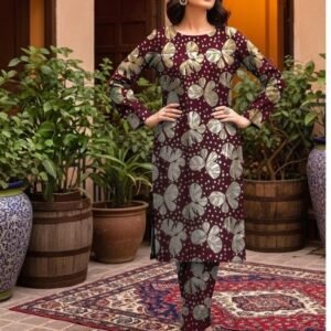 Model posing on a traditional rug in the maroon variant of the monarch foil 2 piece premium summer lawn suit with silver prints.