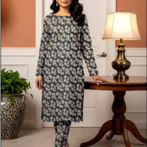 Model standing by a table lamp wearing the charcoal grey variant of the ivy bunch 2 piece premium summer lawn suit with soft ivory prints.